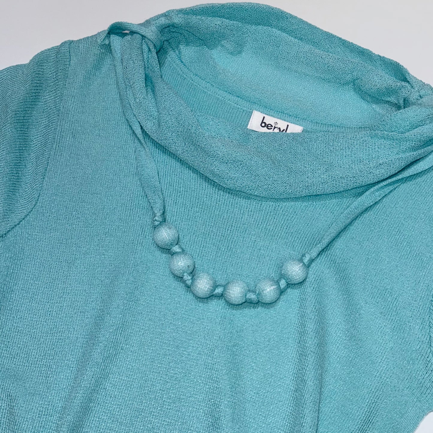 Tiffany blue knit top with bead necklace detail